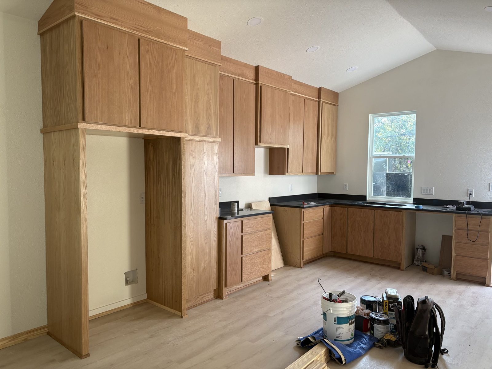 Custom oak kitchen cabinetry installed, awaiting countertops