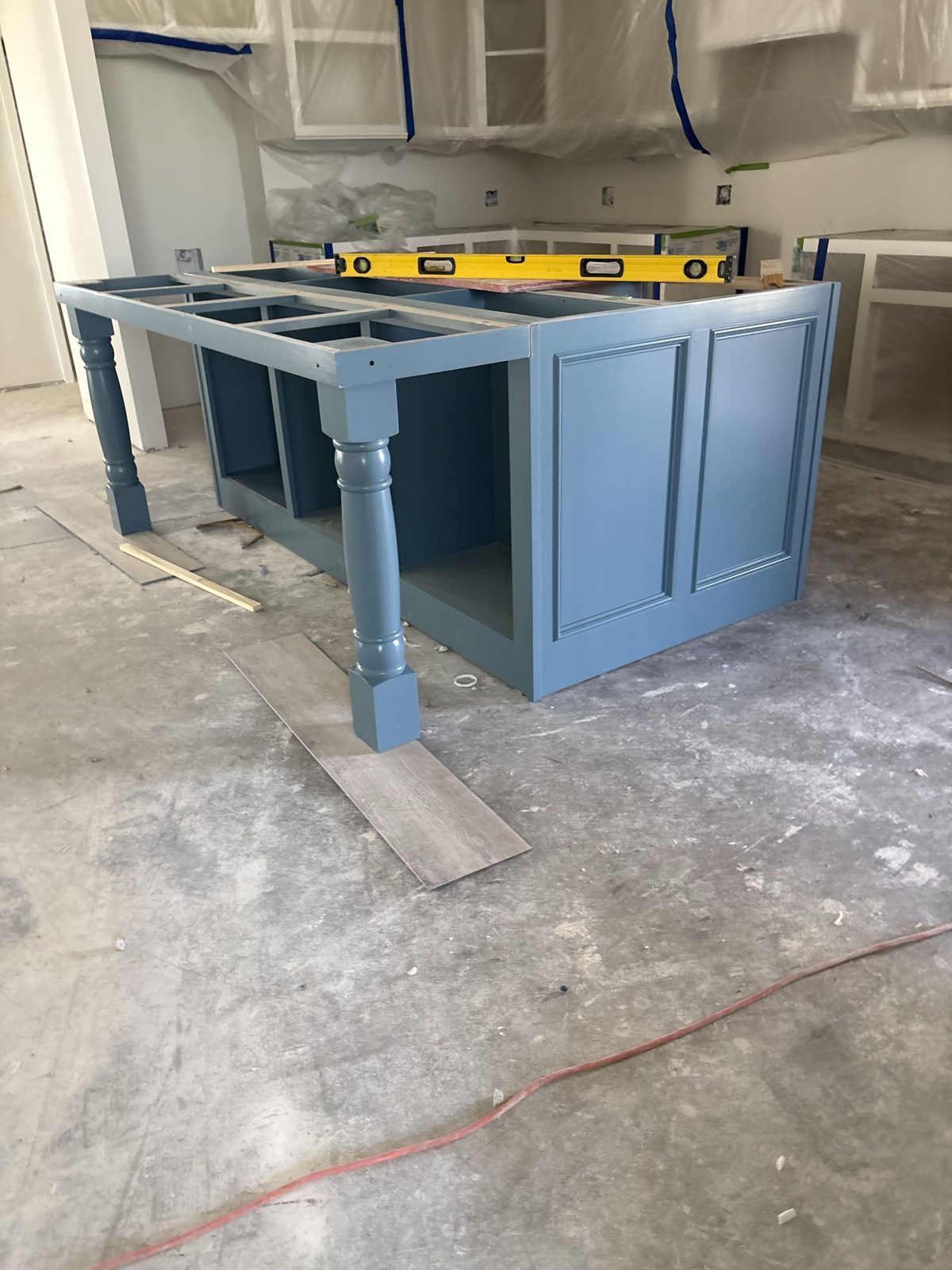 Blue painted kitchen island base being installed