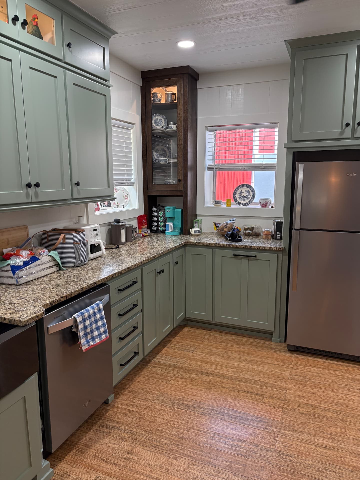 Finished kitchen counter area with sage-green custom cabinetry